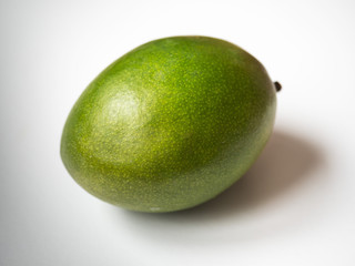 One green mango closeup on a white background