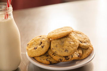 Homemade chocolate chip cookies with a glass of milk on the kitchen table - children's snack
