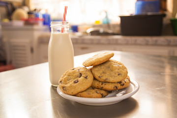 Homemade chocolate chip cookies with a glass of milk on the kitchen table - children's snack
