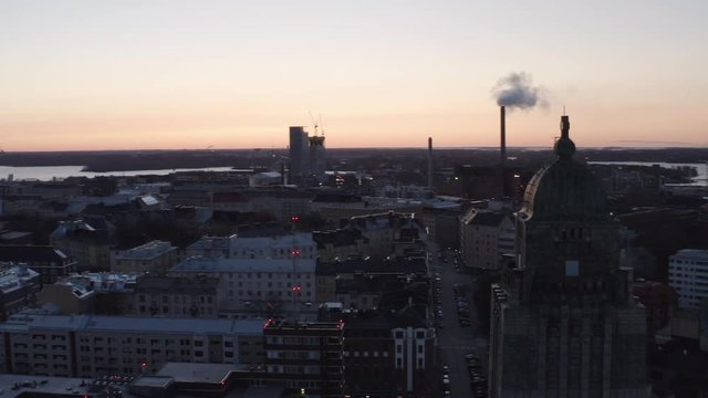Drone shot rotate around high church dome in city center of Helsinki at sunset.