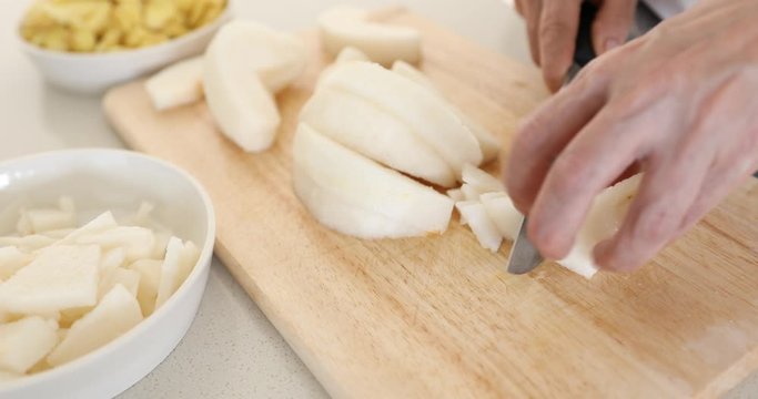 Cutting pears into small pieces on cutting board
