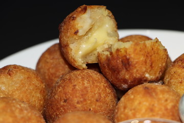 Delicious potato croquettes or cheese balls - mashed potatoes balls stuffed with grated cheese seasoned with spices; breaded and deep fried served with sauce and ketchup