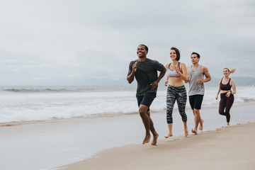 Fit people jogging on the beach - Powered by Adobe