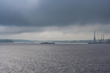 Naklejka premium Rain and clouds over the river and the city