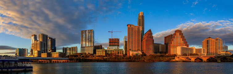 Panorama with downtown view across Lady Bird Lake or Town Lake on Colorado River at sunset golden...