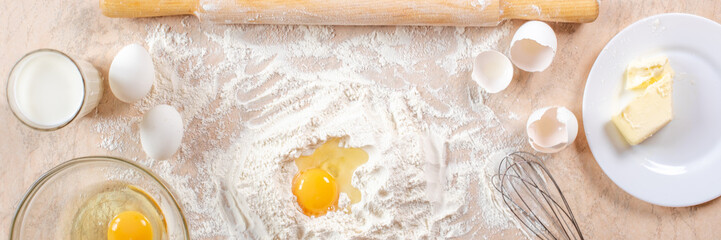 Kitchen table with ingredients for cooking baking. Copy space. Cooking concept. Eggs, flour on background. Dough ingredients. Banner.