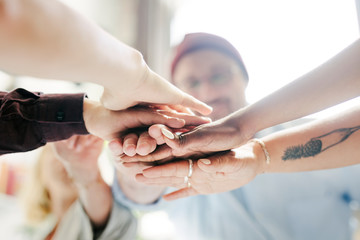 Diverse startup business team stacking hands