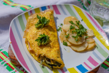 Omelette de huevos orgánicos con aguacate rellenos de espinacas y un toque de perejil