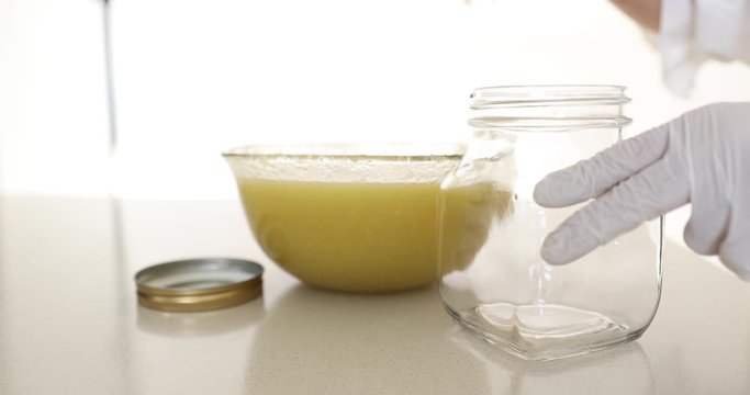 Putting ground pear and ginger into glass jar