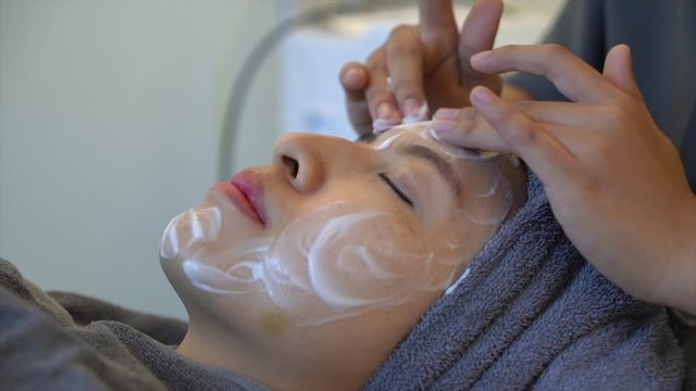 Woman clean skin of the face and receiving massage. Anti aging treatment and plastic surgery concept