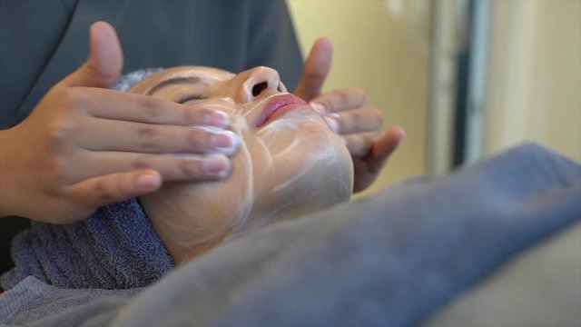 Woman clean skin of the face and receiving massage. Anti aging treatment and plastic surgery concept