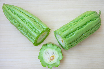 Fresh green bitter melon or Chinese Bitter Gourd on clean wooden background