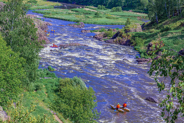 Extreme whitewater rafting trip. A group of people (team) in sport сatamarans practise traversing the water rapids of the mountain river. Active and extreme water sport