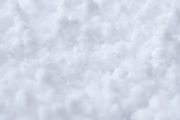 Background of fresh white snow. Winter snowflakes texture. Snow white texture winter background. Icy surface pattern. Shiny snow with bokeh. Macro shot