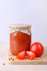 A jar with homemade ketchup on the table with copy space, vertical orientation.