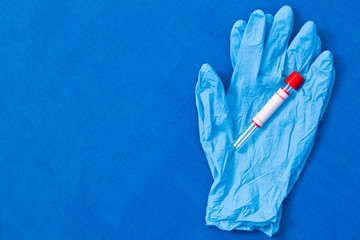 The test tube is blank for text on CORONA VIRUS with rubber gloves on a blue background