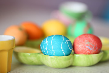 multi-colored easter eggs lie on a green dish
