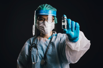 Doctor wearing face shield and PPE suit for Coronavirus outbreak (Covid-19) holding showing...