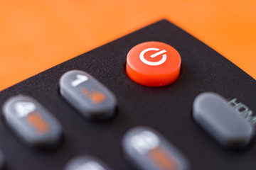 On / off button on the remote control. on an orange background
