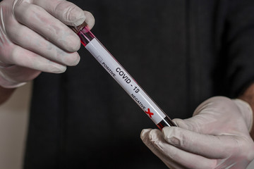 Naklejka premium Conceptual photo - testing for coronavirus: in the hand there is a test tube with a patient s blood sample, which gave a negative result for coronavirus COVID-19