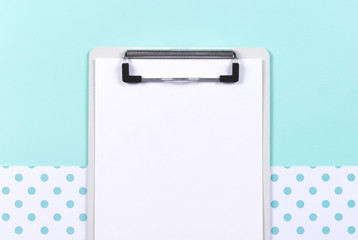 Mockup with white card. Place for text. Clipboard with blank sheet of paper on blue background. Top view. 