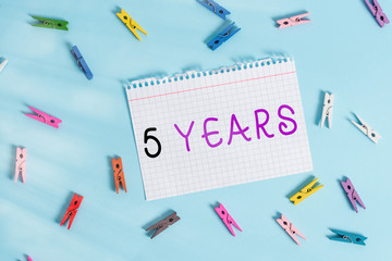 Writing note showing 5 Years. Business concept for Remembering or honoring special day for being 10 years in existence Colored clothespin rectangle shaped paper blue background