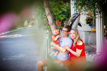 Young average family of three on vacation by the sea