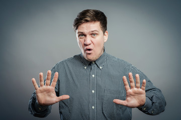 Afraid man in defense attitude gesturing stop with hands
