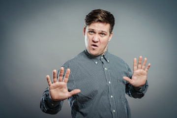 Afraid man in defense attitude gesturing stop with hands