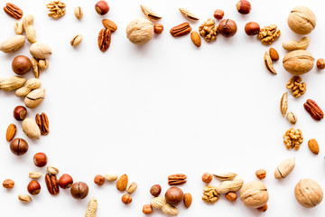 Nuts background - with almond, macadamia, walnut - on white table top-down frame copy space