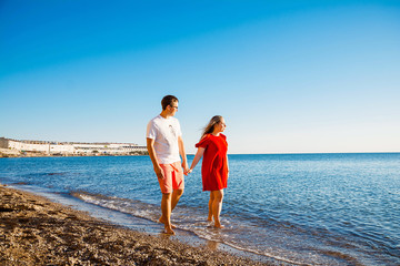 Young average family of three on vacation by the sea