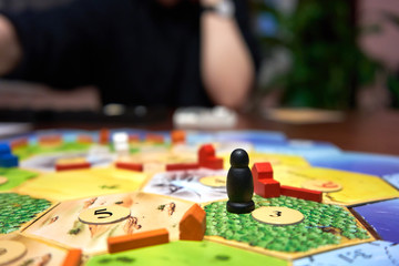 Family is playing board game on the table. 