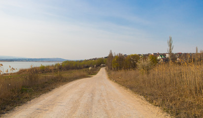 Fototapeta na wymiar Country road near a lake in early spring