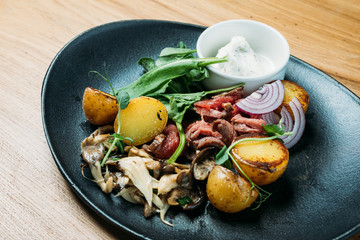 national Russian dish of beef stroganoff from pork, boiled potatoes, mushrooms and sauce on a plate