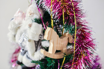 Toy wooden rocking horse in the New Year's interior. New Year's decorations. Decoration of the house. White wooden rocking horse.