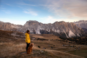 Fototapeta premium person with a dog in the mountains. travel, hiking with a pet. Nova Scotia retriever with a girl.