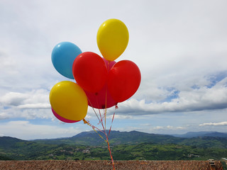 Colorful balloons on the background of the sky and landscape of San Marino. Panoramic view.