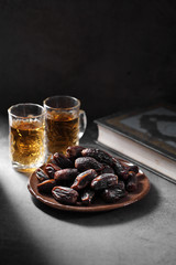 dates fruit and Islamic Book Koran on a concrete background, Islamic background in ramadan