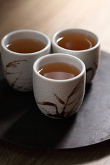 Japanese tea in ceramic cup on wooden tray