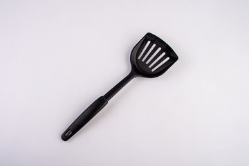 Plastic black spatula for a frying pan isolated on white background.