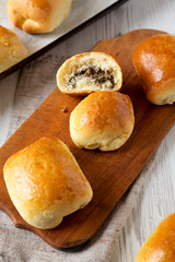 Home-baked Beef Russian Bierocks on a rustic wooden board on a white wooden table, low angle view.