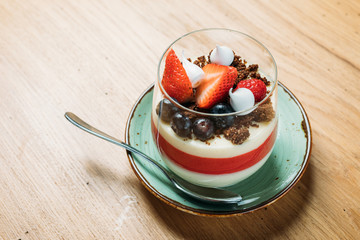 traditional sweet panacotta with berries and strawberries in a glass cup