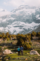 Middle Asia. Tajikistan. Fann mountains. Summer. Beautiful mountain landscape. A couple of people stand with their backs and look at the beautiful mountains. Sports and the elderly. Active lifestyle