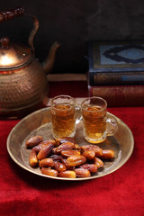 Dates fruit and Islamic Book Koran on carpet background, Islamic background in mosque