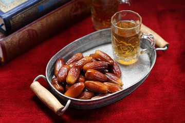 Dates fruit and Islamic Book Koran on carpet background, Islamic background in mosque
