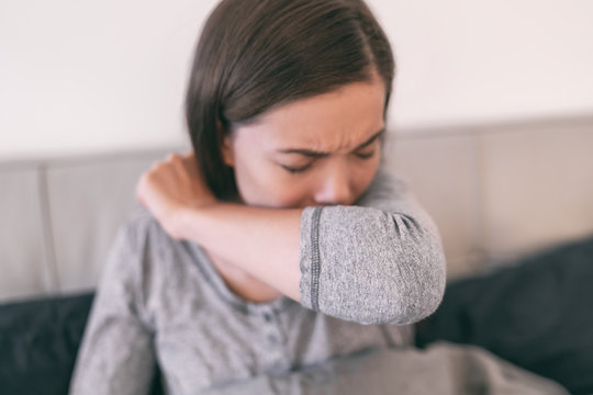 COVID-19 Cover Cough Coronavirus Reducing Of Risk Of Spreading The Infection By Covering Nose And Mouth When Coughing And Sneezing With Flexed Elbow. Young Girl At Home Cough In Arm Prevention.