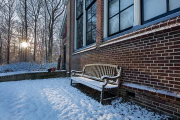 Foto auf Leinwand Bench at old schoolbuilding. Boschoord. Colonial house. Koloniehuisje. Maatschappij van Weldadigheid. Drenthe Netherlands. Sunset. Winter. Snow © A