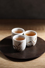 Japanese tea in ceramic cup on wooden tray