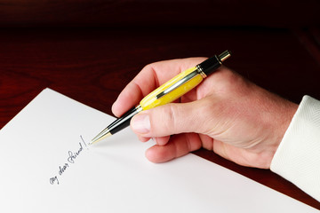Businessman in elegant suit holds a pen in his hands