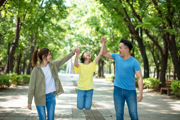 Young asian family with child having fun in nature park